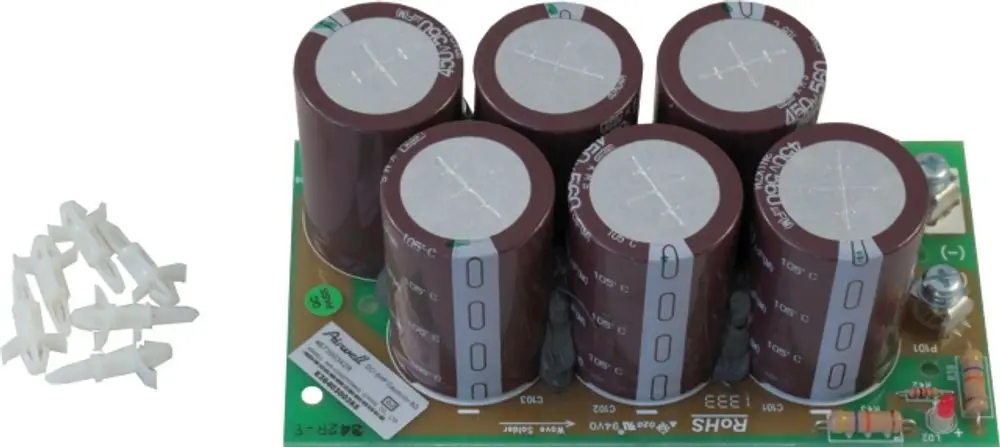 Platinen mit fünf großen Elektrolytkondensatoren, bedruckt mit technischen Informationen, neben weißen Montageclips. Entwickelt für Anwendungen von Wolf.
